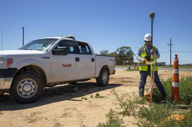 A survey worker next to a white work truck in Lubbock, Texas