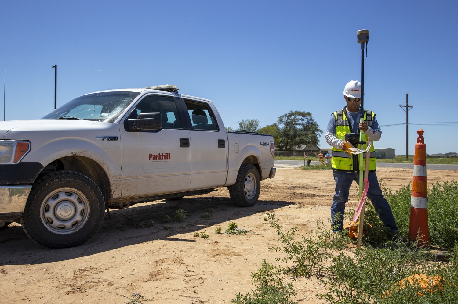 A survey worker next to a white work truck in Lubbock, Texas