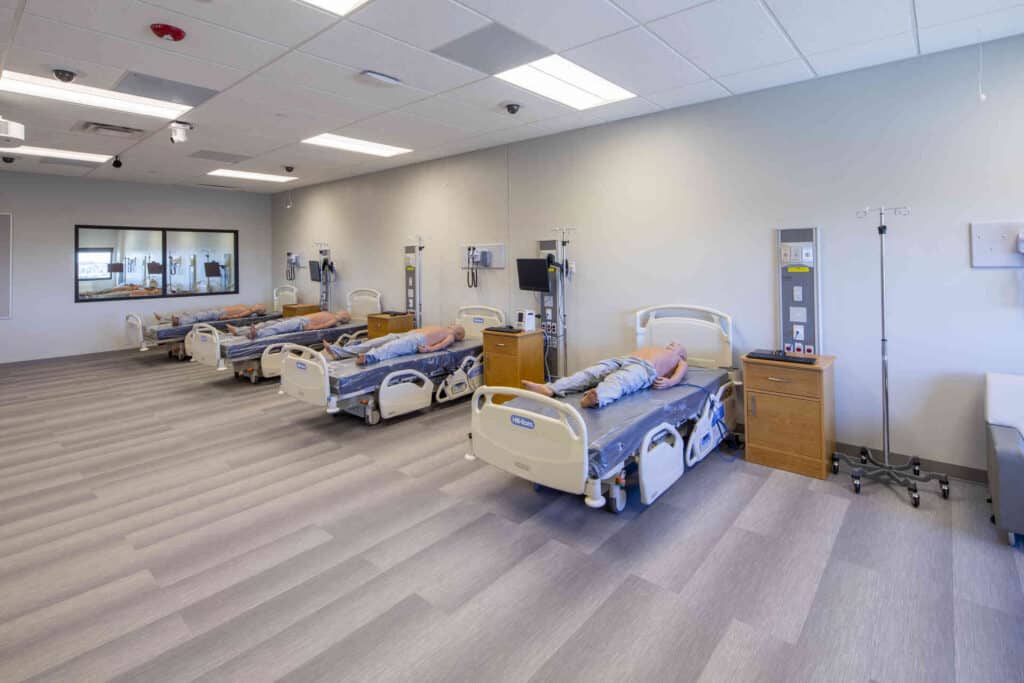 Interior of a hospital room at El Paso Community College Rio Grande Campus, showcasing beds and medical equipment.