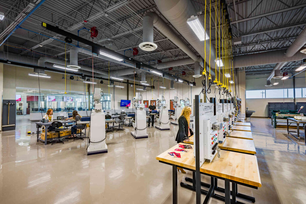 Interior of Texas State Technical College Abilene showing industrial equipment and a hallway with people.